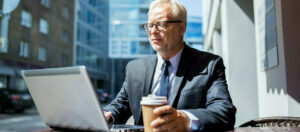 senior businessman with laptop drinking coffee